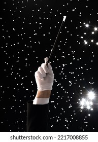 Hand With A Magic Wand On A Black Starry Background