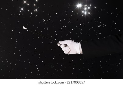 Hand With A Magic Wand On A Black Starry Background