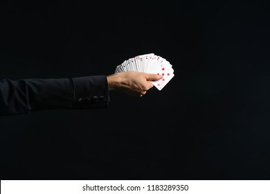 Hand Of Magician Holding Cards On Dark Background