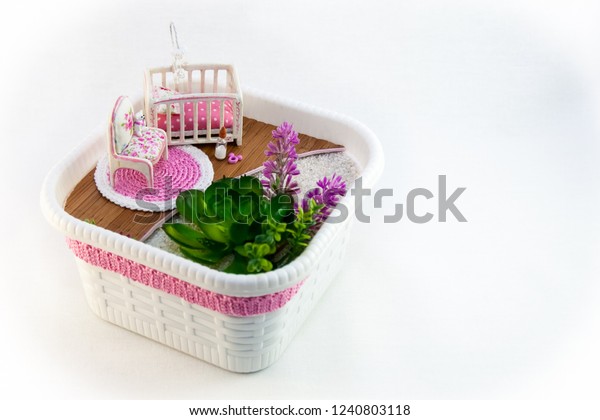 Hand Maid, a hobby pink toy room with a cot for
baby. Little bear sits on a chair. The room also has flowers on the
white sand.