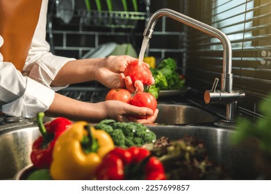 Hand of maid washing tomato fresh vegetables preparation healthy food in kitchen - Powered by Shutterstock