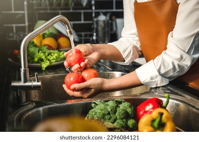 Hand of maid washing tomato fresh vegetables preparation healthy food in kitchen - Shutterstock ID 2296084121