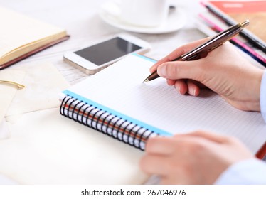 hand makes a note in notebook