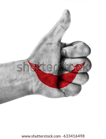 Hand making thumbs up sign. Easter Island Rapa Nui painted with flag as symbol of thumbs like,up,okay. Isolated on white background.