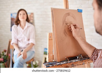 Hand of male artist drawing his muse