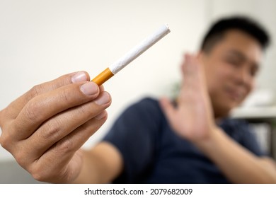 Hand Of Male Smoker Holding A Cigarette,raising Hand To Refuse Smoking,practice Of Restraining Oneself From Drug Addiction,asian Man Rejecting Cigarette,Say No,Stop,quit Smoking,health Care Concept