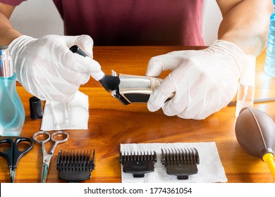 Hand Of Man Is Brush Hair And Cleaning On Hairclipper After Their Use, Cleaning To Prevent The Virus After Use To Eliminate Germs,
Haircut Accessories And Equipment Cleaning Kits On Wooden Table.