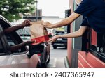Hand Man in car receiving coffee in drive thru fast food restaurant. Staff serving takeaway order for driver in delivery window. Drive through and takeaway for buy fast food for protect covid19.