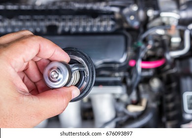 Hand A Man With Car Thermostat For Maintenance