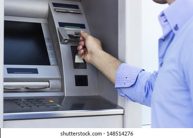 Hand of man with credit card, using a ATM