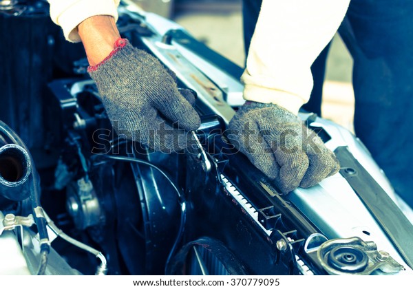 hand of man fixing a broken\
engine