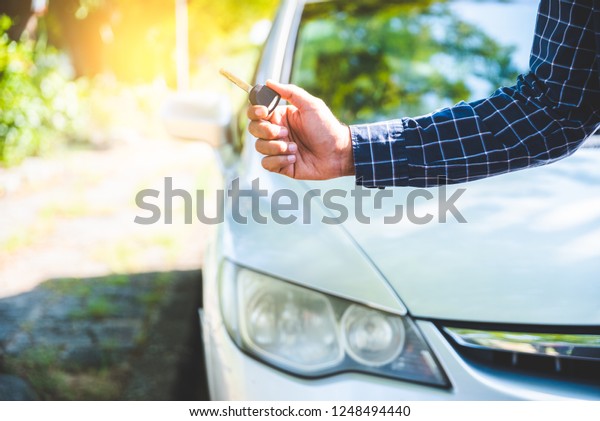 Hand man getting his key outside car. Concept of\
rent car or buying car.