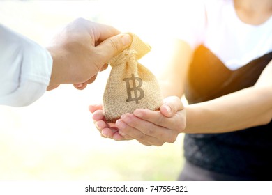 Hand Of Man Give Bag Symbol Money On Women's Hand, Mutual Aid Concept And Investment And Care.