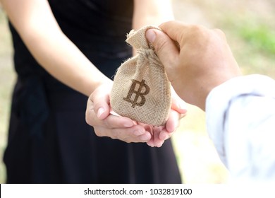 Hand Of Man Give Money Bag On Women's Hand, Mutual Aid Concept Business And Investment.