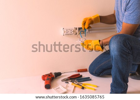 hand man glove hold outlet and connectors conduit on wall, electrician maintenance installation, contractors, craftsman, handyman, plug,  wiring,
