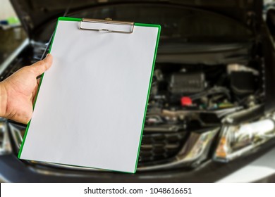 Hand a man hold check sheet paper for maintenance concept of car 