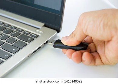 hand man hold Flash drive connect to USB port plug-in computer laptop for transfer data and backup business concept 