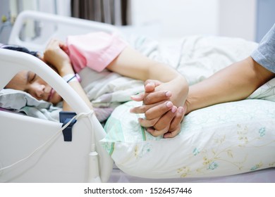 Hand of man hold hands with woman on the hospital bed. Patient and hospital concept. - Shutterstock ID 1526457446