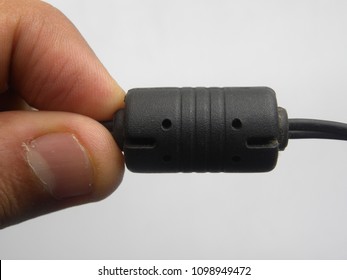 Hand Of Man Holding Black Color Ferrite Bead Inductor