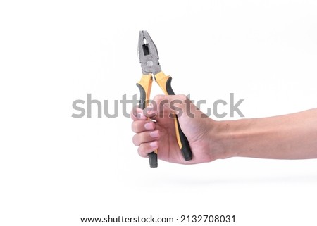 The hand of a man is holding a black yellow pliers isolated on the white background