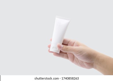 Hand Of Man Holding Mockup Product About Cream Or Lotion In Tube Isolated On White Background, Face Foam, Alcohol Gel, Skin Care, Package Of Treatment And Moisturizing, Design And Presentation.