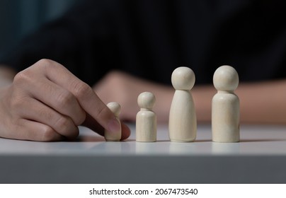 Hand of a man holding wooden family figures, Family concepts - Powered by Shutterstock