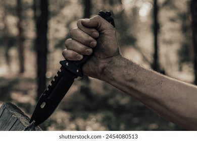 Hand man with hunting knife for survival in the forest. Concept recreation and survival in forest - Powered by Shutterstock