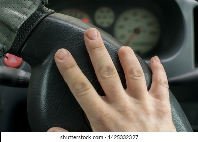 Hand Of A Man With A Missing Finger Phalanx On The Background Of The Steering Wheel And Dashboard Of The Car