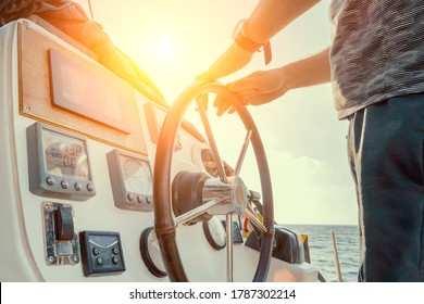 Hand of man on the steering wheel sailboat. Hands on the sailboat's steering wheel. Man's Hands with clocks Steering Wheel Of Yacht. Close-up of a man's hands on the yacht steering wheel. Helm yacht - Powered by Shutterstock