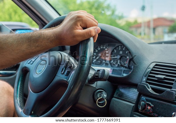 Hand of a
man on the steering wheel of a car
closeup
