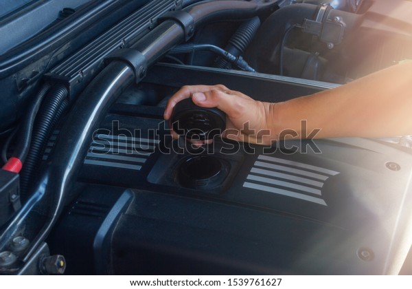 Hand man\
open oil cap on motor machine for check\
oil.