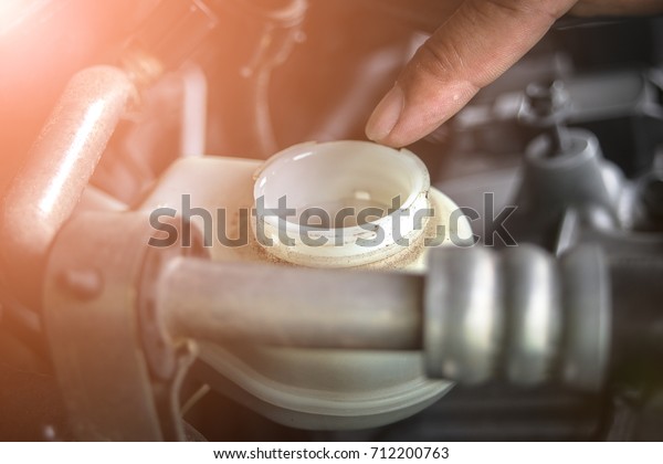 Hand man opening to brake fluid tank for\
check  - Car maintenance