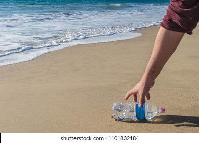 Hand Man Picking Up Plastic Bottle Cleaning On The Beach. Volunteer Concept.