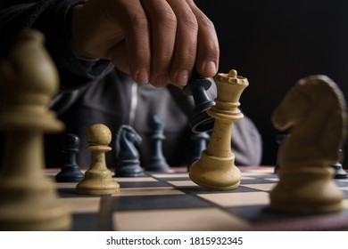 Hand eines Mannes, der Schach spielt und die Königin tötet