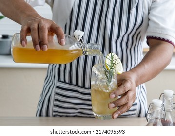 Hand Of Man Pouring Kombucha Tea Into A Glass, Kombucha Fermented Drink, Bacteria And Yeast,  Fermentation, Probiotic, Scoby, Mushroom Pro Biotic, Healthy Fermented Tea