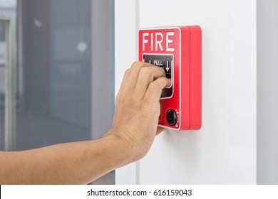 Hand Of Man Pulling Fire Alarm Switch On The White Wall As Background For Emergency Case At The New Factory Building.