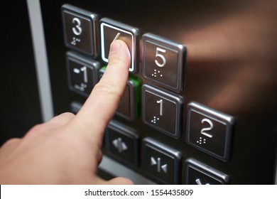 Hand Of Man Pushing Braille Alphabet Elevator Button