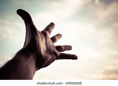 Hand of a man reaching to towards sky. Color toned image. - Shutterstock ID 149028368