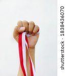 The hand of man with red and white ribbon as symbol Indonesian flag.