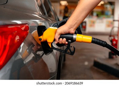 Hand Man Refill and filling Oil Gas Fuel at station. Gun petrol in the tank to fill. Pumping gasoline fuel in car at gas station. Refueling automobile with gasoline or diesel with a fuel dispenser.
