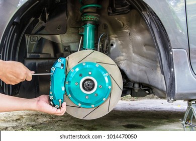 Hand and man remove nut lock caliper pad on the caliper brake repair concept and maintenance of car 