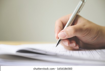 Hand of man signing signature filling in application form document - Shutterstock ID 1656186583