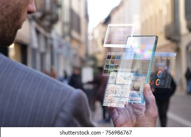 The hand of a man in suits, uses a futuristic glass phone with the latest advanced holographic technology. Concept of: future, technology, smartphone, augmented reality - Powered by Shutterstock