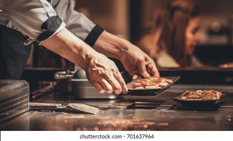 Hand of man take cooking of meat with vegetable grill, Chef cooking wagyu beef in Japanese teppanyaki restaurant - Powered by Shutterstock