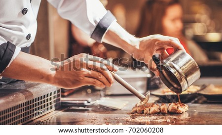 Hand of man take cooking of meat with vegetable grill,Chef cooking wagyu beef in Japanese teppanyaki restaurant