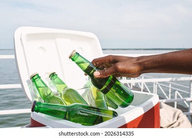 Hand Of Man Taking Glass Bottle Of Cold Tasty Beer Out Of Cooler Box When Attending Party On Pier