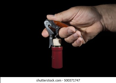 hand man using corkscrew to open a bottle of wine