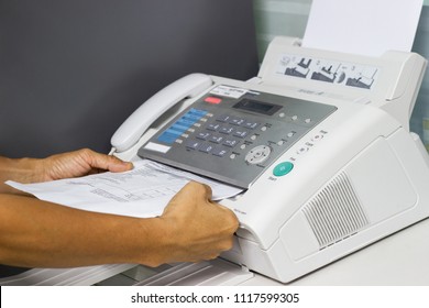 hand man are using a fax machine in the office Business concept 