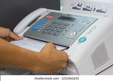 Hand man are using a fax machine in the office Business concept 