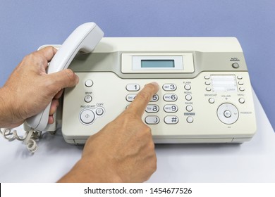 hand man are using a fax machine in the office Business concept 